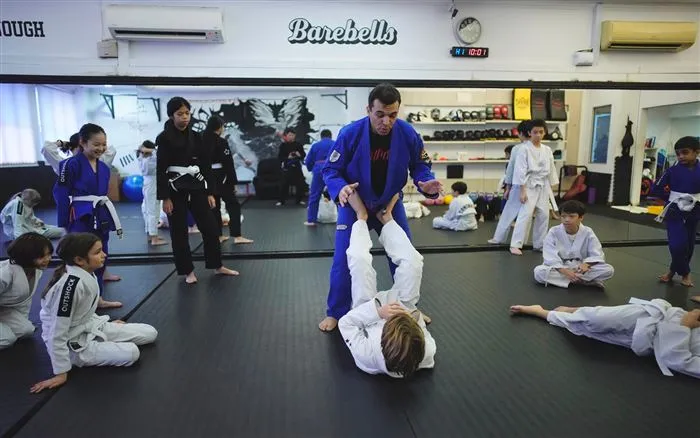 An instructor teaching a full class of kids Brazilian Jiu-Jitsu at the studio