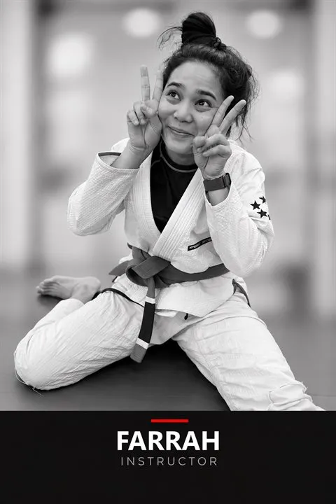 Black-and-white portrait of Farrah Yong, Brazilian Jiu-Jitsu Kids instructor at JEET Academy KL, in a gi giving a peace sign