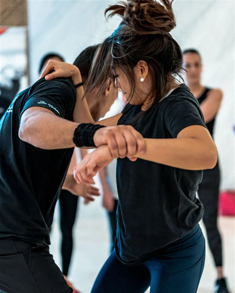 A participant defending against a wrist grab during a corporate LEVEL UP workshop