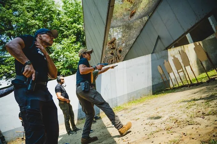 Team members in Jeet Academy KL shirts training at an outdoor firearms range