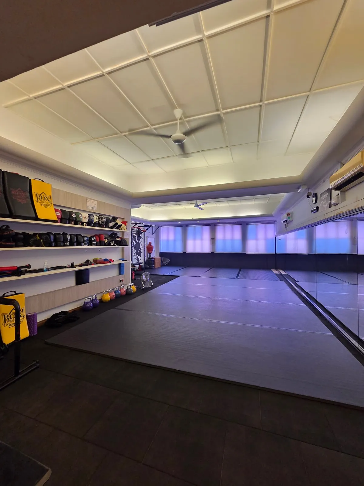 The Jeet Academy KL training floor - mats, mirrors and a wall of gloves, pads and kettlebells