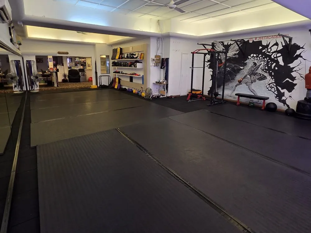 The matted training floor at Jeet Academy KL, with the studio mural at the far end